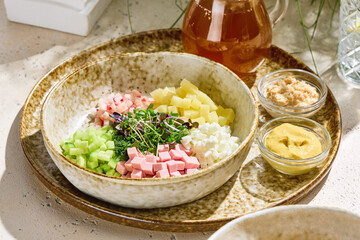 Okroshka with kvass, bright natural lighting, overhead composition in rustic ceramic bowl