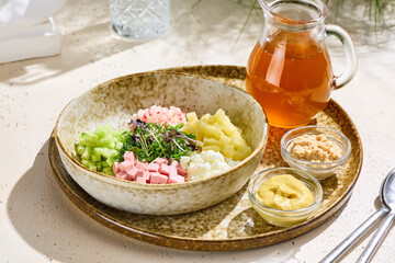 Okroshka with kvass in natural daylight, overhead minimal composition on rustic ceramic plate