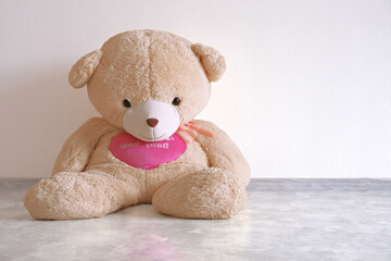 Plush teddy bear sits against a plain white wall, capturing the essence of childhood and nostalgia.
