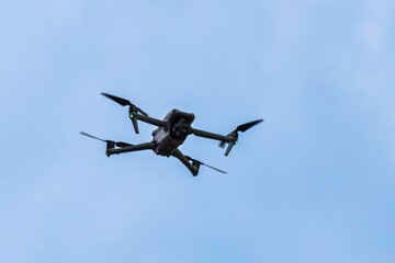 Drone hovers in the air. Drone with camera, unmanned flying object.
