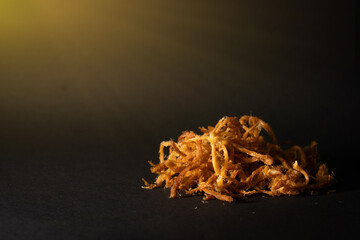 Crispy dried shredded pork isolated on black background. Closeup