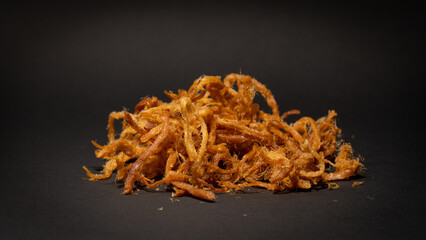 Crispy dried shredded pork isolated on black background. Closeup