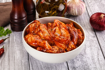 Raw marinated buffalo chicken wings