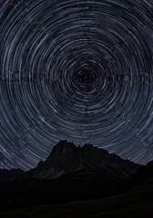Fototapeta premium Star Trails Over Mountain Landscape at Night with Clear Skies