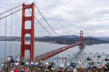 Golden Gate Bridge framed by metal love locks attached to scenic overlook fence, San Francisco, CA, January 30, 2021