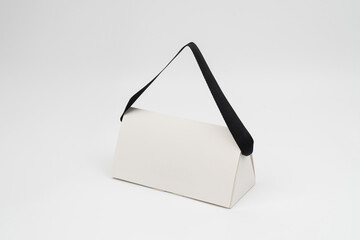 Minimalist Triangular Gift Box with Black Handle on White Background