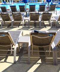Deck furniture near a swimming pool.