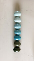 Gradient of blue colored eggs arranged vertically