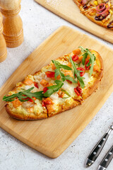 oval pizza with tomatoes and arugula