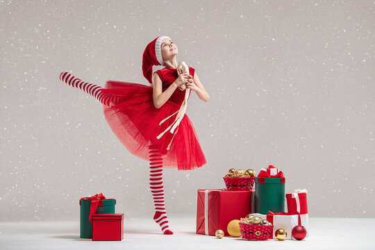 Girl ballet dancer wearing elf costume with tutu skirt and santa hat.