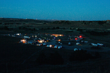 Night view of RVs and tents lit at Sage Creek Campground, Badlands