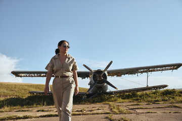 Woman by old plane in field