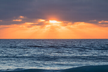Golden sunset illuminating ocean waves in sagres, portugal
