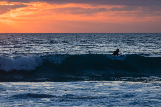 Surfer waiting for the right wave at sunset in the algarve, port