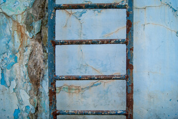 Rusty Ladder Against Weathered Concrete Wall Under Overcast Sky