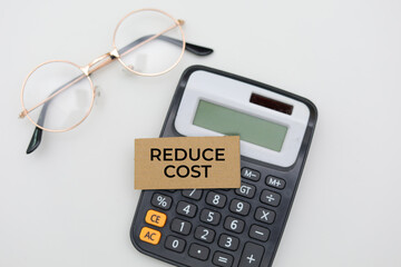 Calculator and Glasses with Reduce Cost Text - Business and Investment Concept
