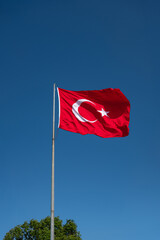 Turkish flag. Waving in the blue sky. Republic of Turkiye.