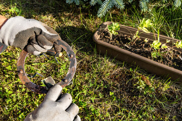 Woman cleans rust from rusty old garden lamp with sandpaper,