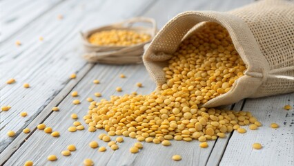 Golden lentils spilling from a burlap sack onto a rustic wooden surface showcase their natural texture and vibrant color ideal for food blogs culinary websites and healthy eating content.