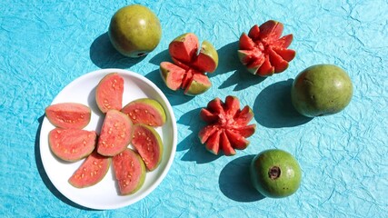 Fresh Guava fruits carved in flower shape with red pulpy inside. Jaam phal amrood fruits in wicker basket