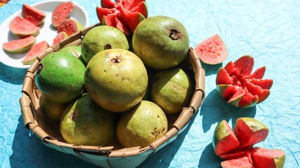 Fresh Guava fruits carved in flower shape with red pulpy inside. Jaam phal amrood fruits in wicker basket