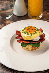 Eggs Benedict with poached egg, bacon, spinach and hollandaise sauce
