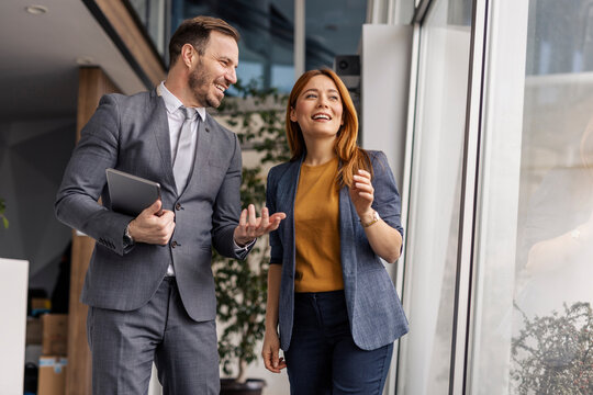 Portrait of corporate staff smiling and discussing at lobby.