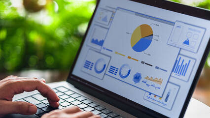 Business analyst reviewing digital charts and data on interactive performance dashboard.