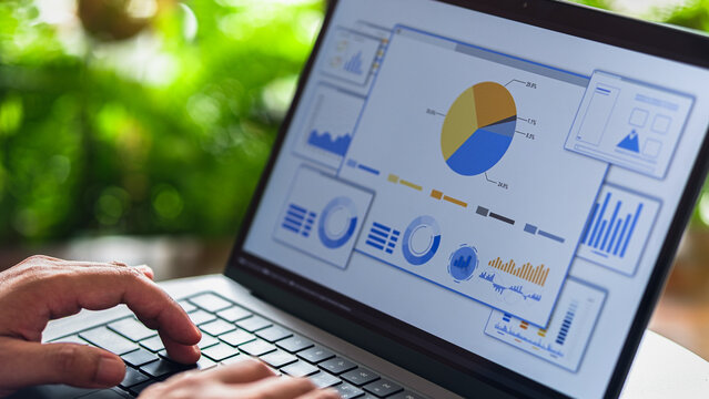 Business analyst reviewing digital charts and data on interactive performance dashboard.