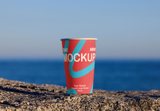 Sustainable takeaway cup placed on a rocky surface. PSD template mockup