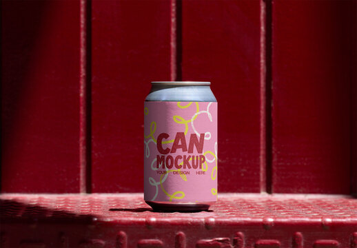 A blank can stands prominently against a bold red backdrop, showcasing its potential for unique designs and branding. PSD template mockup.