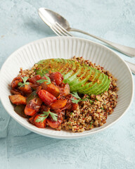 Quinoa bowl with avocado, nuts and tomatoes
