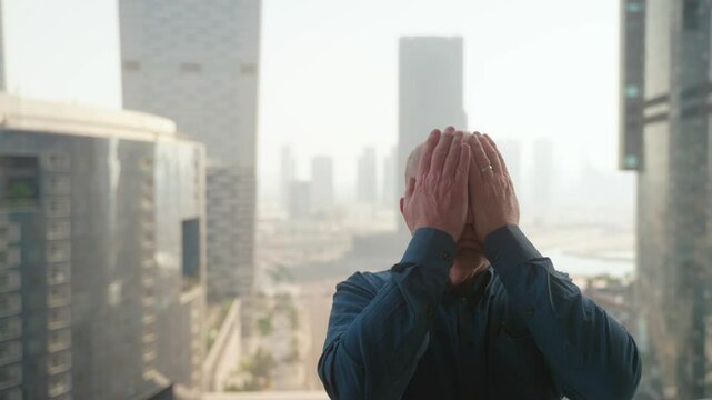 Senior man presses record on his camera then poses with different emotions for a social media video thumbnail with a cityscape in the background