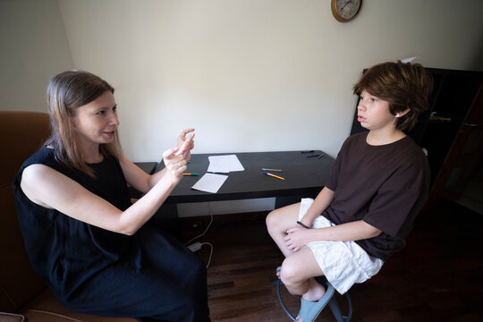 Speech therapist helping teenage boy with communication difficulties