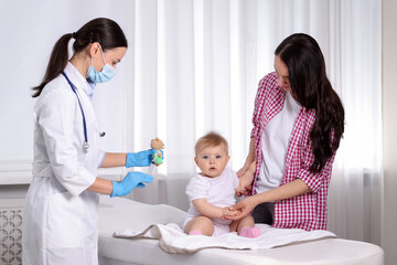 Fototapeta premium Mother and her cute baby having appointment with pediatrician in clinic