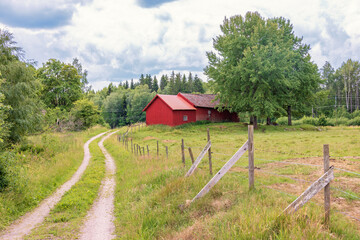 Red barn by a winding dirt road in the countryside