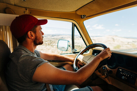 Man driving vintage vehicle through Grand Staircase Escalante desert - Powered by Adobe