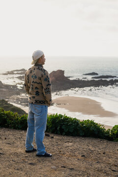 Surfer looking at the ocean in sagres, algarve, portugal