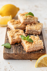 Lemon crumble bars on wooden cutting board, oatmeal lemon bars