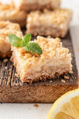 Lemon crumble bars on wooden cutting board close up. Oatmeal lemon bars