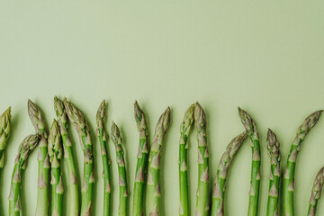 Fresh asparagus on green background top view with space for text