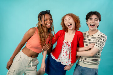 Portrait of diverse Generation Z friends posing on isolated blue screen. 