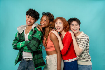 Portrait of diverse Generation Z friends posing on isolated blue screen. 