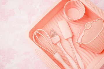 Pink silicone baking utensils set in tray on pink background