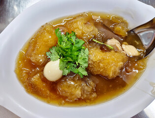 Fish maw soup with quail egg served on a plate, a famous Chinese food.