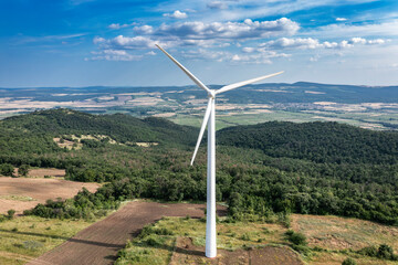 Aerial view to rotor blades of wind turbine in wind park on the hill