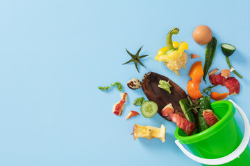 Composting concept. Fresh vegetable and fruit scraps ready for recycling next to a bin.