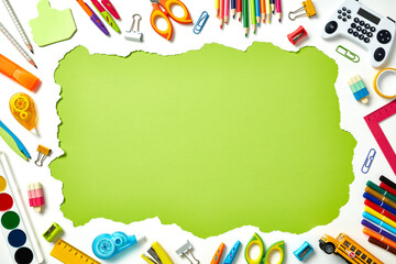 Back to school concept. Frame of school supplies on white background with green copy space for text...