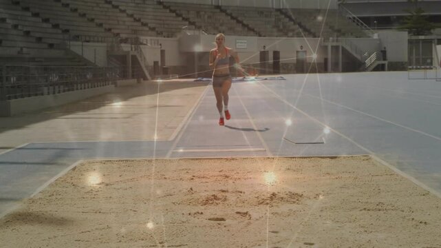 female athlete starting run accelerating toward takeoff board and landing in sandpit for long jump