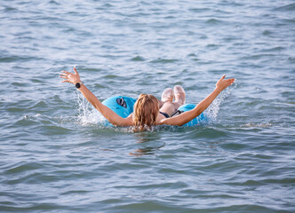A young girl swims in the sea on an inflatable circle